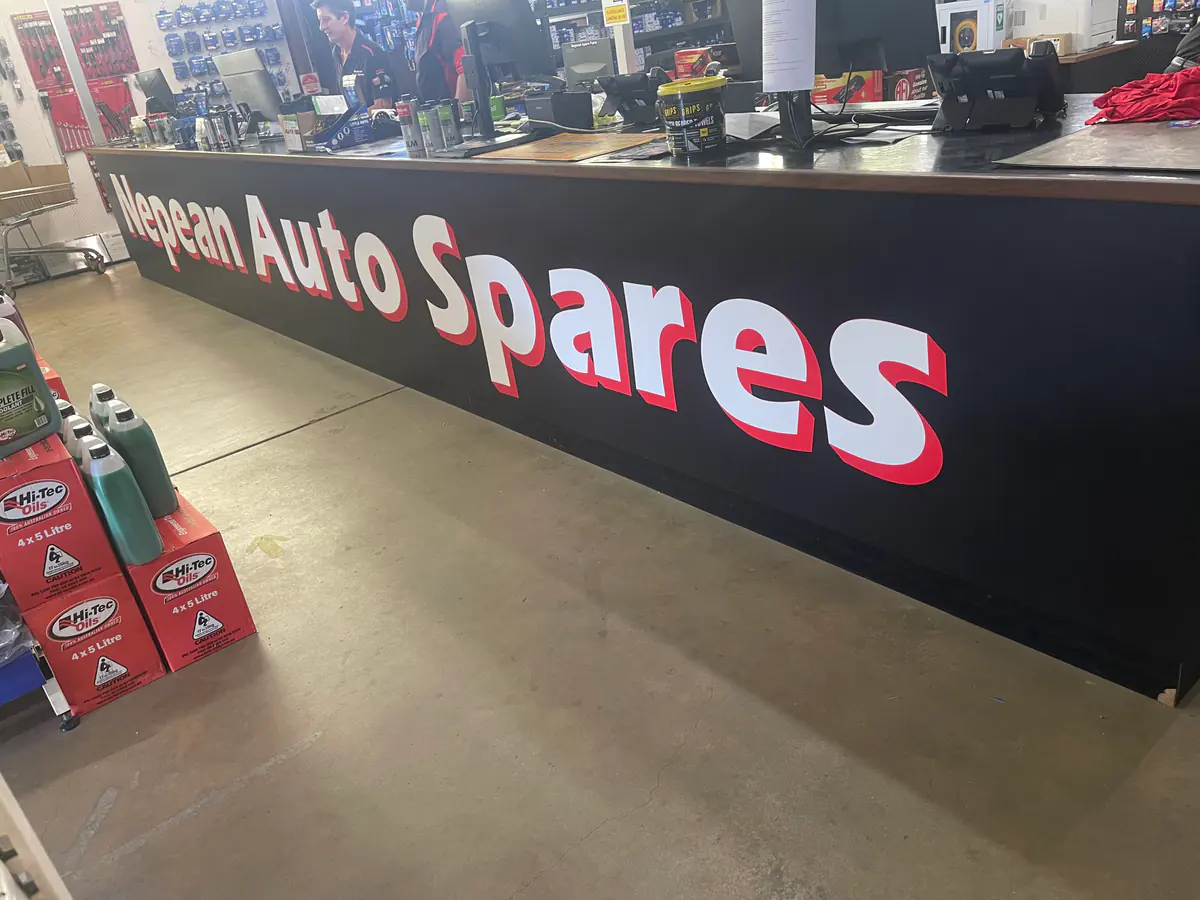 Branded Nepean Auto Spares counter signage inside an automotive store