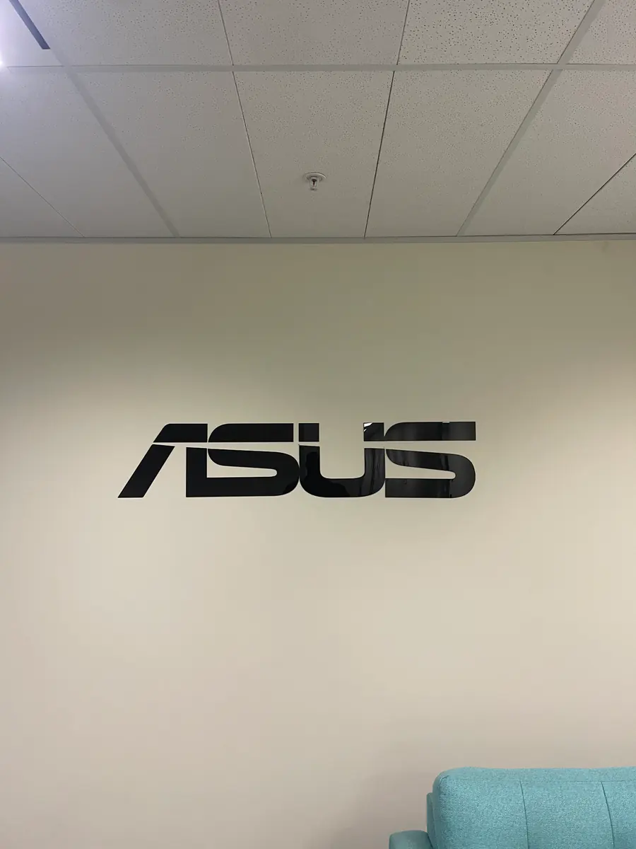 Black dimensional ASUS logo installed on a corporate reception wall