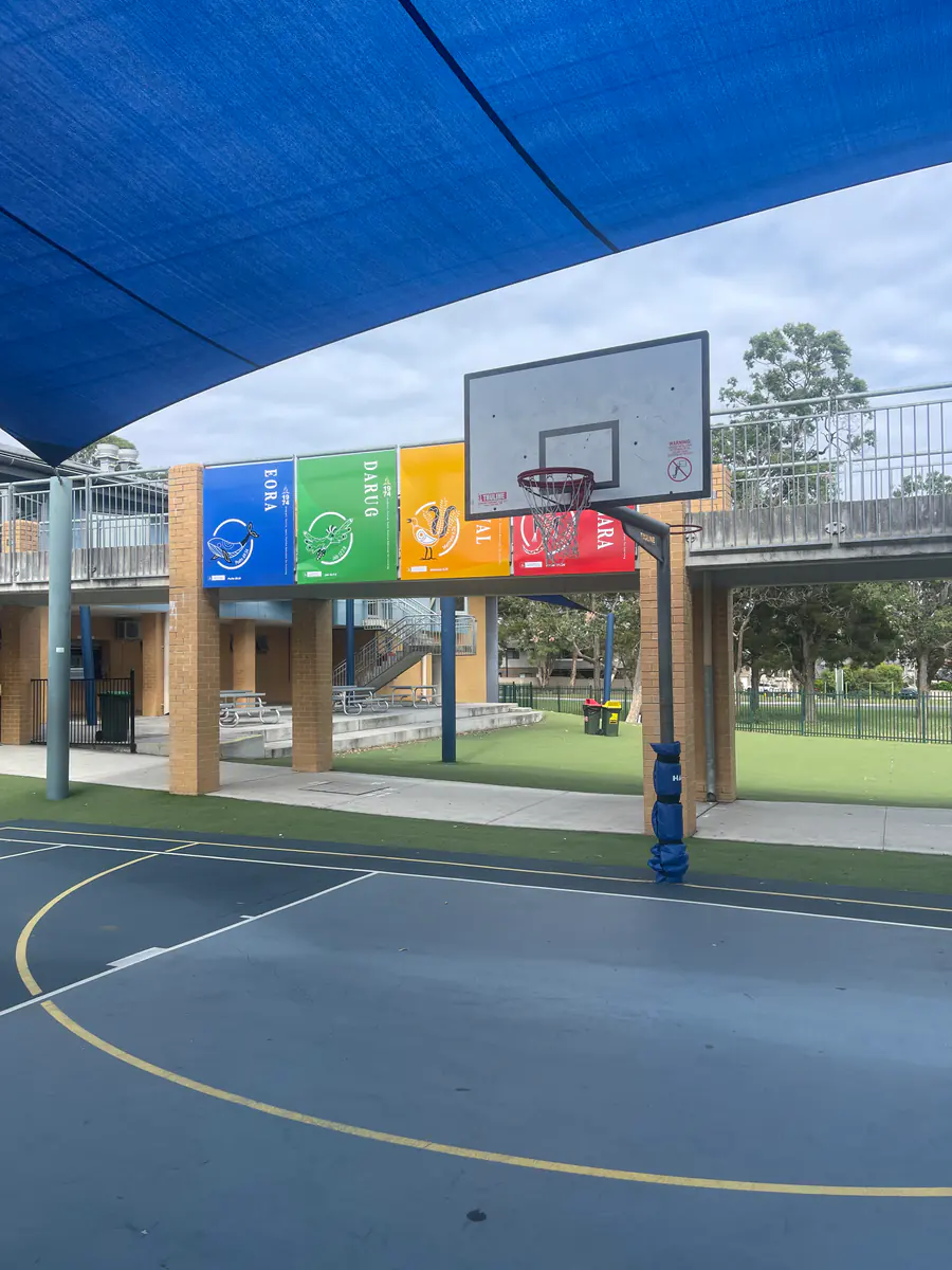 Colour coded school house banners installed beside an education courtyard