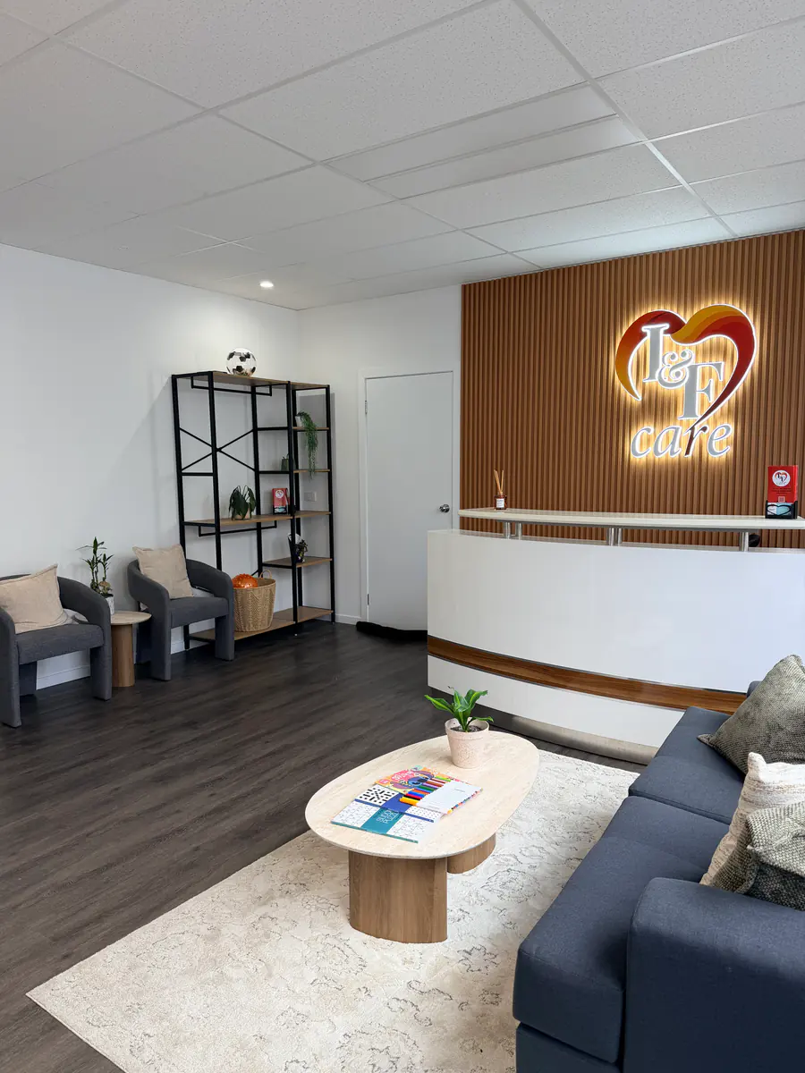 Illuminated healthcare reception signage installed on a timber feature wall